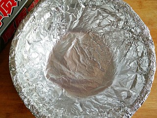 5、开心花甲――味美颜高满足嘴巴的“虚荣心”,锡纸裁成45*45cm一张(选择比较厚实不容易碎裂的锡纸）。将裁好的锡纸放入圆型器皿里，然后用手轻轻拍打，使锡纸窝起来成碗状。