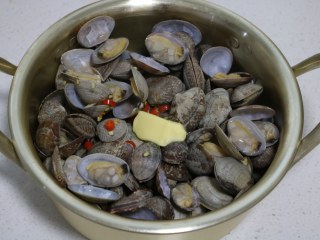 8、深夜食堂之酒蒸蛤蜊,开盖看蛤蜊开口就好了，加入黄油块，关火盖盖子焖1分钟。