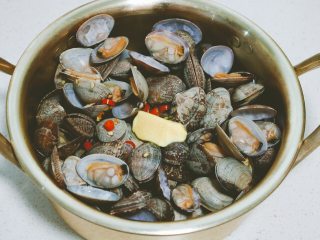 9、深夜食堂之酒蒸蛤蜊,用勺子搅拌一下，让融化的黄油均匀包裹蛤蜊。