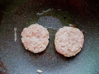 8、田园猪肉堡,锅内放少量油,放入肉饼小火煎制。待晃动铁锅肉饼可移动,翻面。两面煎至金黄后,加入少许清水。盖盖焖至水干,开盖再煎片刻即可。