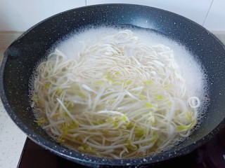 5、猪油拌面,待面条煮过一分钟后加入豆芽煮。