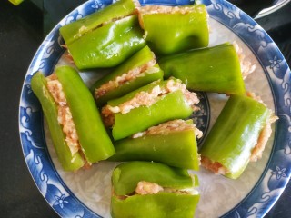 6、尖椒酿肉,把肉馅夹在尖椒中放入盘子里