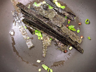 16、云吞面,放入葱和海苔翻炒一下。