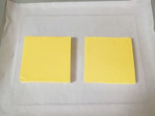 5、芝士面包片,烤盘铺上油纸,放上吐司芝士片。 烤箱上下管180度预热。