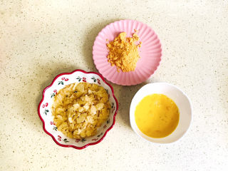 9、薯片鸡翅,将按压碎的薯片倒入碗里,准备好鸡蛋液,新奥尔良烤翅腌料倒进碟子里