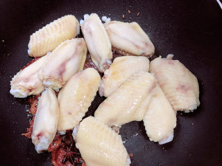 10、薯片鸡翅,放入鸡翅中翻炒均匀。