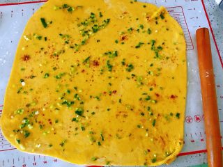 3、南瓜水煎花卷,用擀面杖擀薄,加入盐,五香粉和葱花,放上橄榄油刷匀称。