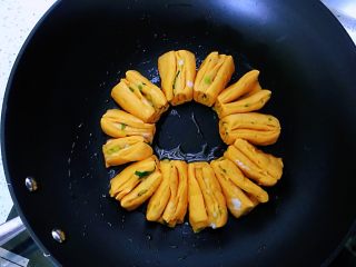 7、南瓜水煎花卷,平底锅刷薄薄的一层橄榄油,加油有点温度,平底锅保持有温度是为了方便后面的发酵,缩短发酵时间。做好的花卷挨个挨个摆成圆圈放上去。