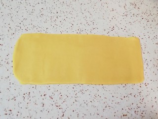 5、枣泥一口酥,先取一半面团(另外一半盖上保鲜膜，防止风干)，擀成长方形的面片(擀制的过程中可以借助刮刀将面片裁成长方形，裁下来的边角料继续放在面片中间进行擀制)。