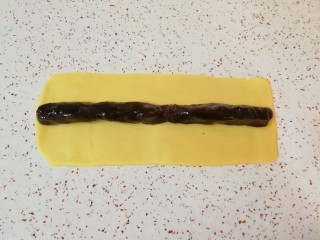 6、枣泥一口酥,取一半的枣泥馅搓成长条状，放在面片的中间。