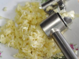 6、蒜香油泼小龙虾,用压蒜器把蒜压成蓉状。