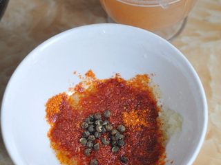 8、蒜香油泼小龙虾,舀三勺蒜蓉酱，加入辣椒粉，最上面放上麻椒。