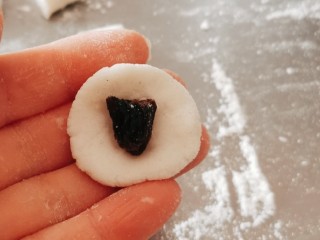 10、红豆汤圆,取一份按压成圆片  包上葡萄干