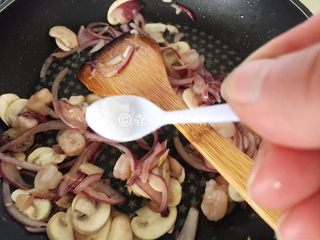 14、小龙虾奶酪快手酥饼,等蘑菇片变软,就把虾肉放入,再撒上小半勺盐,翻炒均匀。