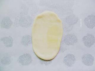 6、糖火烧,取第一只包好的饼皮，按扁，擀成牛舌状