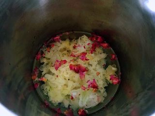 3、银耳玫瑰花羹,冰糖银耳和玫瑰花全部放入到豆浆机或者破壁机中，加入900毫升的水，启动机子按钮至自动结束工作。