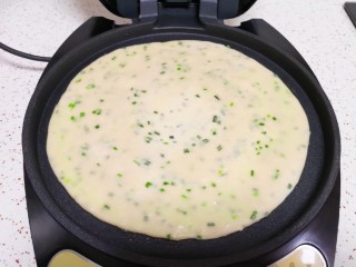 12、小蒜酱香饼,电饼铛预热，刷上一层食用油，放入做好的饼胚，饼的表面也刷上一层食用油。