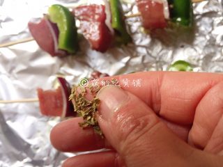 9、烤牛肉串,还可以撒上丢丢的香料碎（可选），入烤箱，180度，25分钟左右（具体时间、温度，请根据自家烤箱灵活设定。）