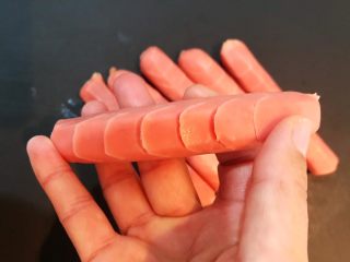 5、黑椒烤肠,把烤肠两边切斜刀，每隔1㎝切一刀，深度7㎜，烤肠对称的两边都切好