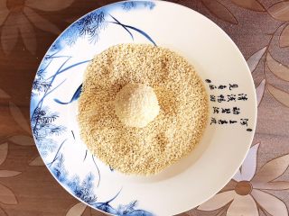 12、香炸麻团,再用手把表面的白芝麻压实,一个麻团生坯就包好了