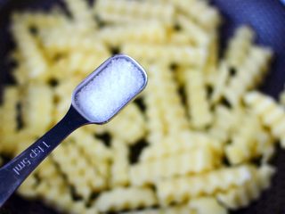 4、炸锅版狼牙薯条,加入适量的盐，这样炸出来的薯条和色泽都很好。