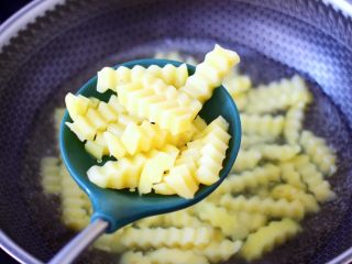 5、炸锅版狼牙薯条,开锅煮2分钟捞出。