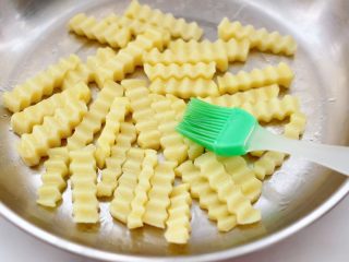 8、炸锅版狼牙薯条,把冷冻好的土豆条，均匀地涂抹一层薄薄的食用油。