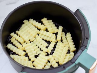 9、炸锅版狼牙薯条,空气炸锅提前200度预热5分钟后，把抹好的土豆条放入炸篮里。