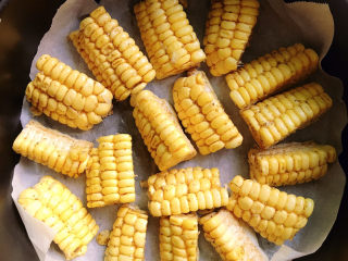 9、孜然烤玉米,炸篮中铺上一层油纸，将玉米平铺在上面。