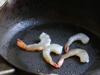 7、海鲜咖喱乌冬面,锅中加油烧热，放入剥好的虾煎至七成熟，变色卷曲，盛出待用。