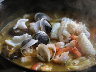 12、海鲜咖喱乌冬面,等汤汁变略浓稠，放入鱿鱼、虾、文蛤煮一二分钟，挑出虾头。