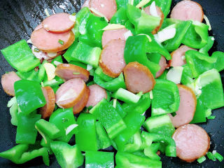 9、青椒炒香肠,加入青椒，继续翻炒。