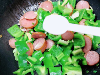 10、青椒炒香肠,加入一勺盐。