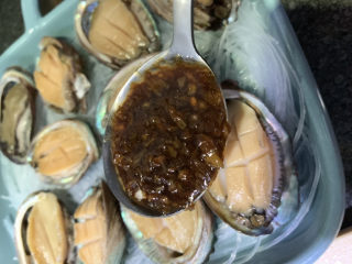 19、蒜蓉粉丝蒸鲍鱼,关火，用勺子一勺一勺舀到每个鲍鱼上；