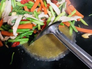 18、芦笋炒肉片,翻炒均匀后加入料酒拌匀，再加入适量开水煮一下，使各个味道融合。