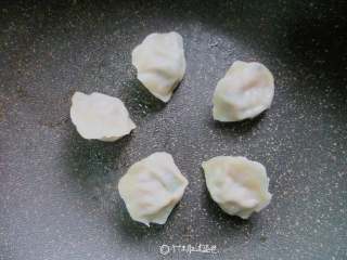 6、冰花煎饺,热锅倒油少许,将速冻饺子整齐的摆放在锅中;