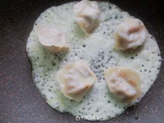 7、冰花煎饺,倒入1勺淀粉水,将锅轻轻晃悠,将淀粉水均匀铺在锅中