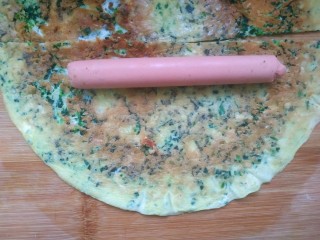 12、菠菜蛋卷,铲出放案板上，切成两半，准备好火腿