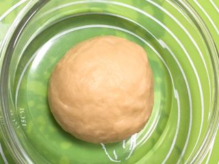 3、芝麻酥饼,整理一下,滚圆放入玻璃碗中,盖上保鲜膜静置30分钟。