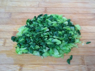 5、青菜油渣包,焯过水的青菜过一下凉水，挤干水分切碎。