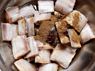 6、炸鱼块,加入花椒粉搅拌均匀。