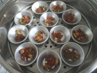 10、钵仔糕,把模具放入屉中，加入葡萄干，枸杞子，红枣碎