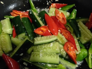 8、美味宵夜小龙虾,十几秒后,待蒜蓉散发出香味,放入黄瓜、青椒、红椒爆炒