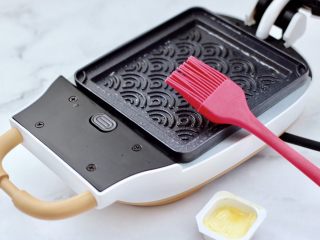 2、鸡蛋蜜豆热压三明治,三明治提前预热后，刷上一层薄薄的黄油。