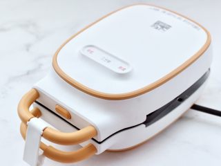 4、鸡蛋蜜豆热压三明治,盖上盖子煎1分钟，喜欢吃火大一点可以焖的时间再长一点。