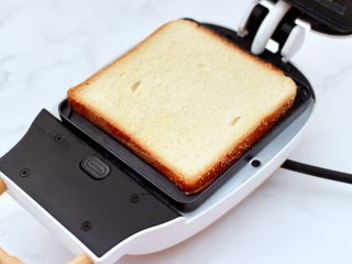 6、鸡蛋蜜豆热压三明治,先放入一片吐司。