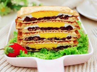 12、鸡蛋蜜豆热压三明治,做好的三明治，用刀一切两半就可以享用了。