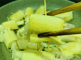 8、豆皮金针菇卷,转中小火煎，一面金黄，翻另一面，