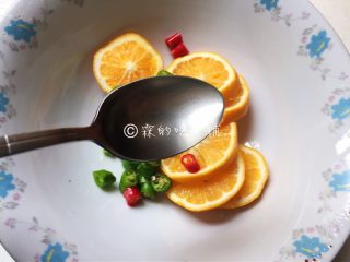 8、酸辣爽口的柠檬鸡翅根,取一干净容器,把柠檬片和辣椒放入,再加入白醋。