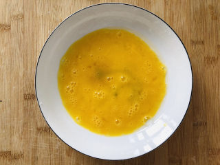 6、烤馒头片,找一个深一点的盘子,倒入打好的蛋液。